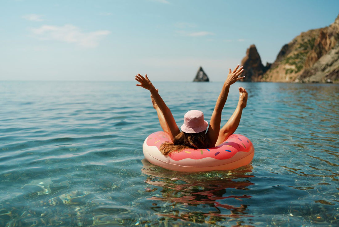 woman wearing a bucket hat floating in the ocean, enjoying vacation