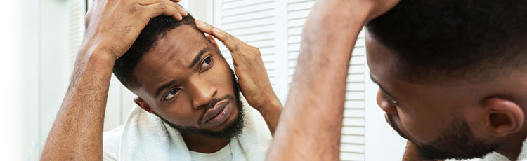 Man examining his sideburns in the mirror