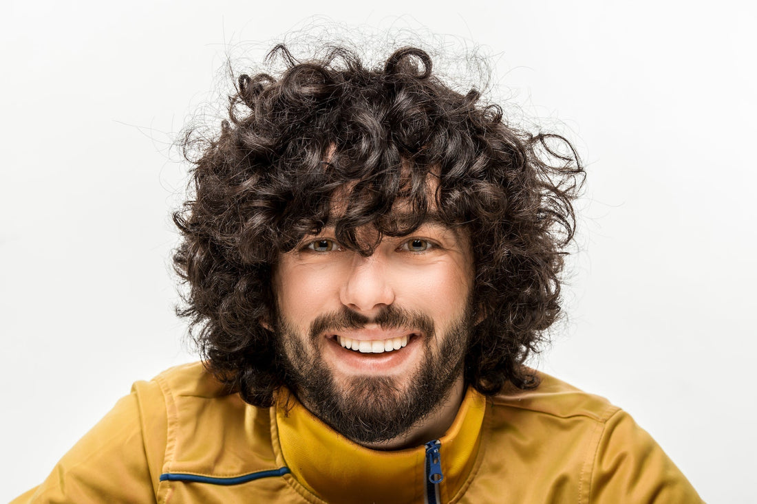 Smiling man with curly hair and a beard