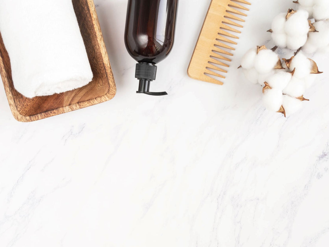 Towel, dispenser bottle, and cotton on a marble table