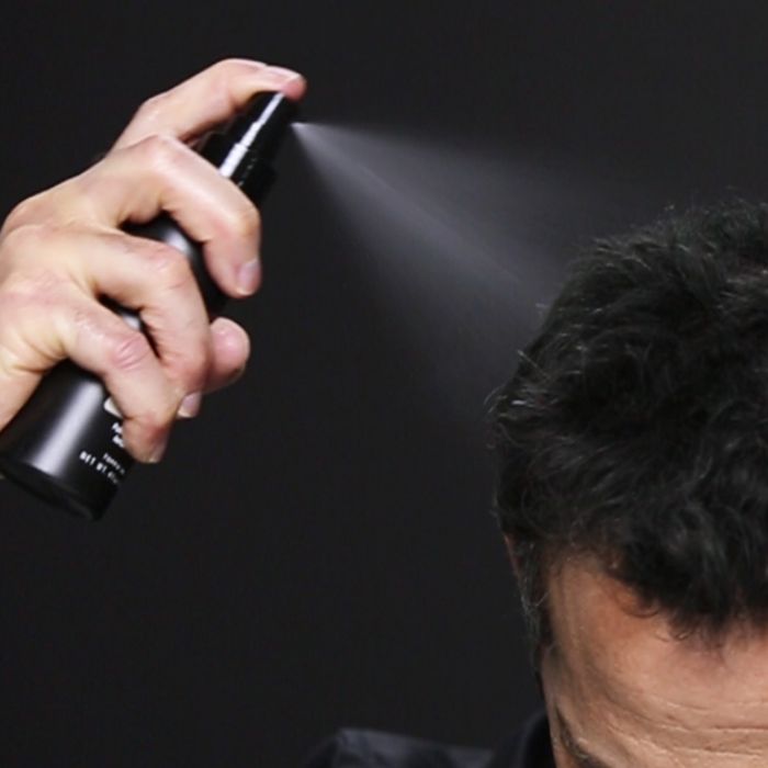 Man spraying Toppik fiber hold spray 