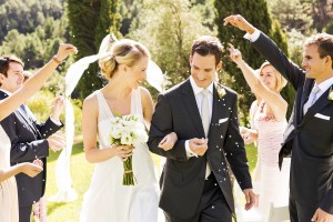 Couple Walking While Guests Throwing Confetti On Them