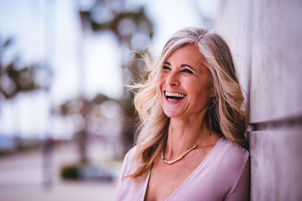 smiling happy woman long gray hair causes gray hair toppik blog post