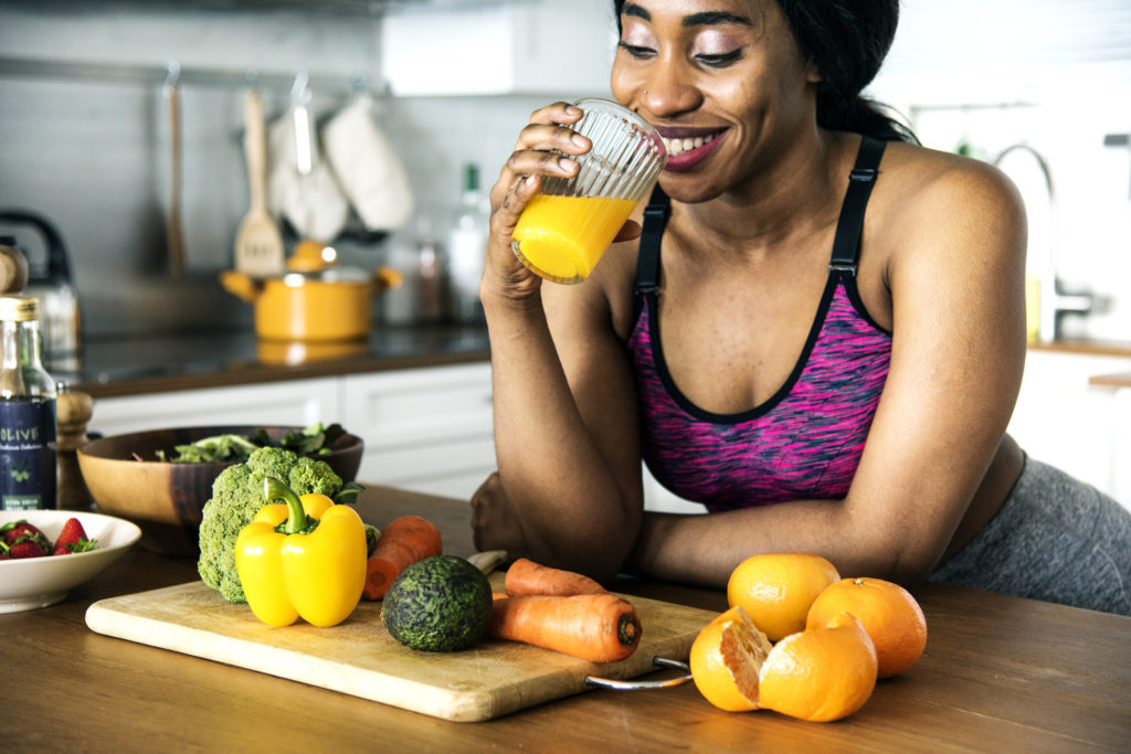 Black woman drinking orange juice healthy diet maintaining healthy hair follicle function toppik hair blog